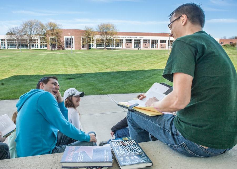 Students study and talk while sitting on the stairs at Ohio University's Zanesville campus.